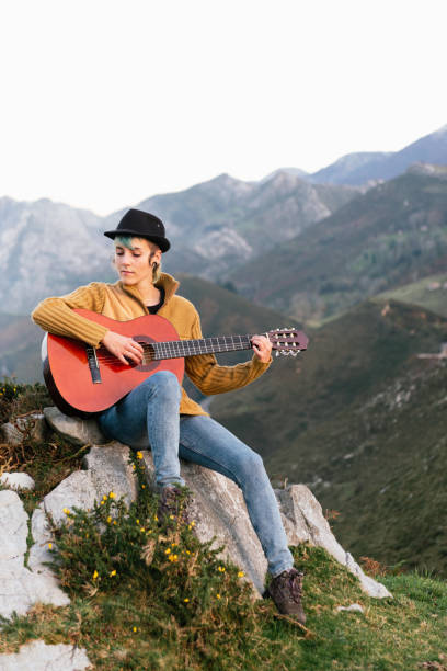 istock young woman playing guitar in the mountains 1288905481