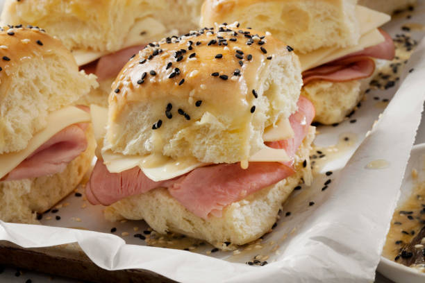 istock Preparing Baked Ham And Swiss Sliders on White Tray Buns 1288905588