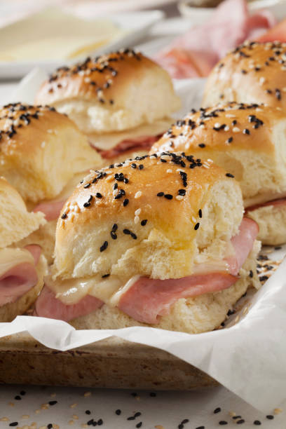 istock Baked Ham And Swiss Sliders on White Tray Buns 1288906181