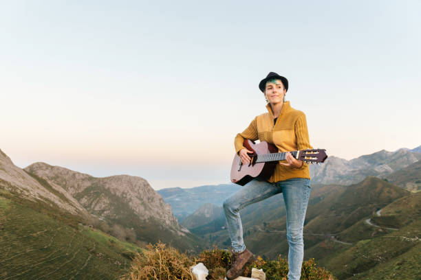 istock young woman playing guitar in the mountains 1288906187