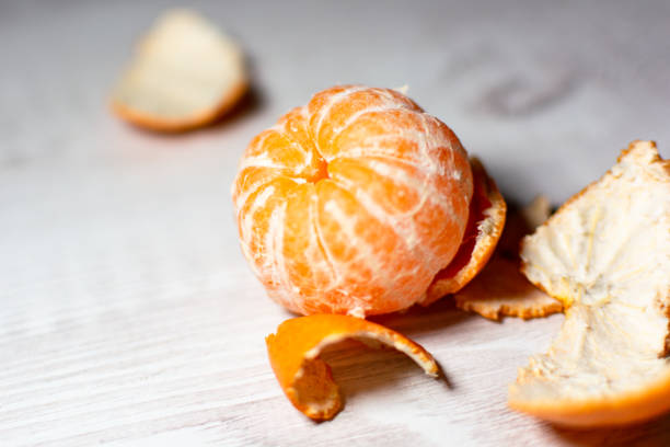 istock Peeled ripe juicy mantarin on the kitchen table 1288909572
