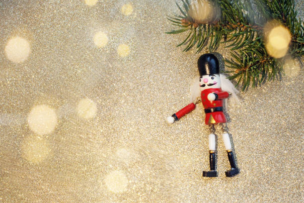 istock toy Nutcracker on a spruce branch on a white wooden background with lights 1288910170