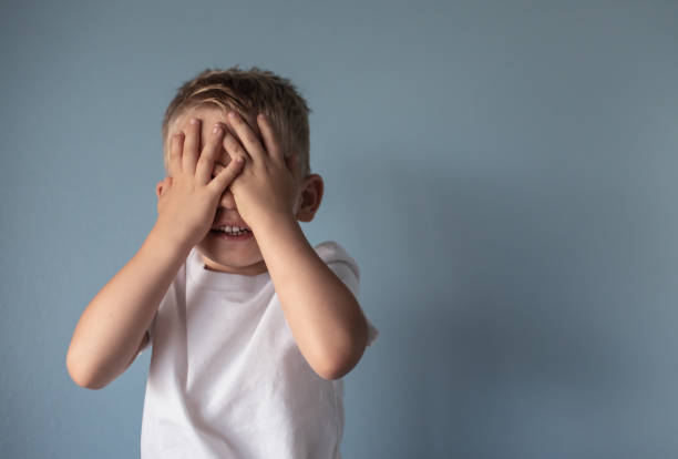 petit garçon couvrant ses yeux - mains devant les yeux photos et images de collection