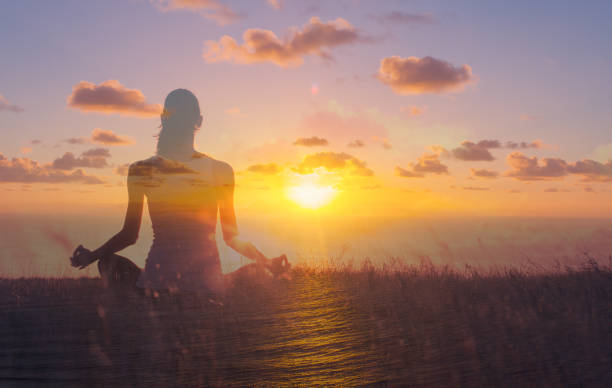 istock Woman meditating at sunset. 1288911582