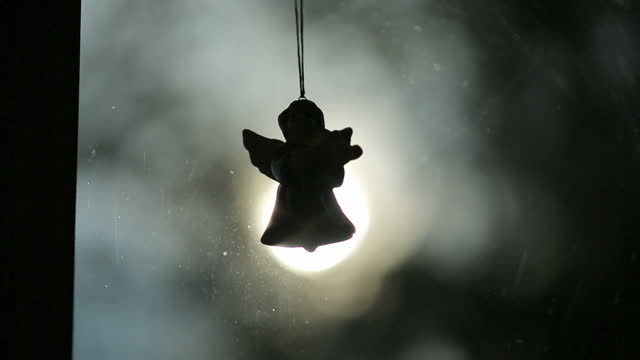 Angel hanging over blurry light