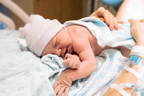 Mother holding her newborn baby in the hospital stock photo
