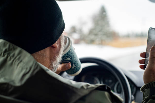 istock Distracted driving.  A man driving while holding a coffee and texting. 1288913508