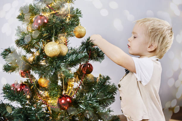 istock A small boy with white hair stands at the elegant Christmas tree 1288913688
