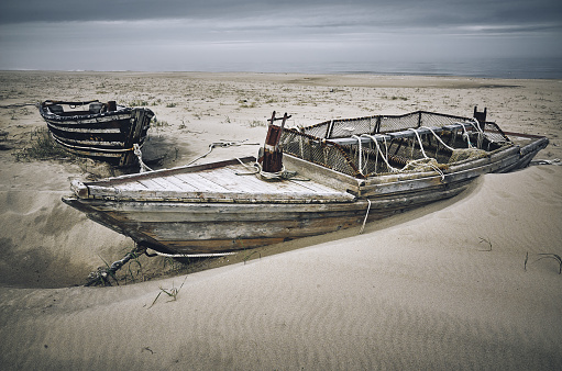Fishing  lonely wooden boats on the beach sand near the coastline, Sakhalin island, Russia