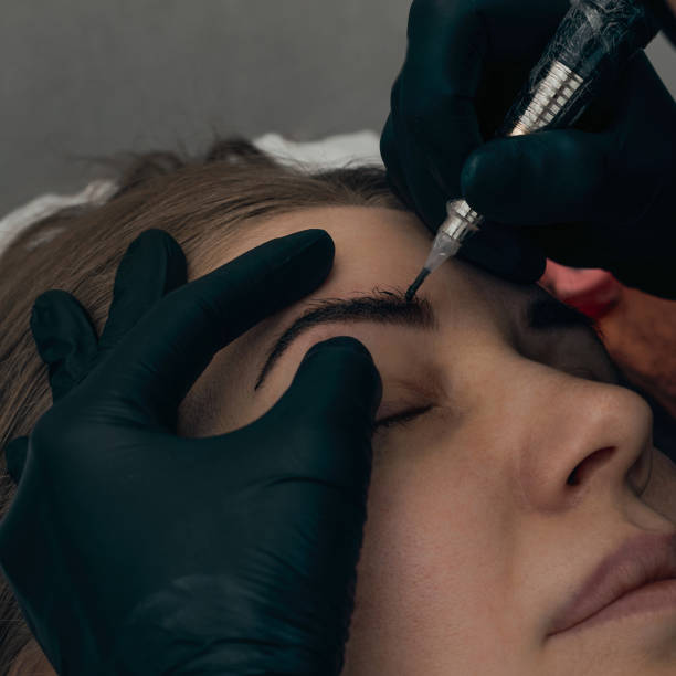 istock Permanent eyebrow makeup procedure. Eyebrow tattooing, process. The use of tools by a master for permanent eyebrow makeup. 1288921057