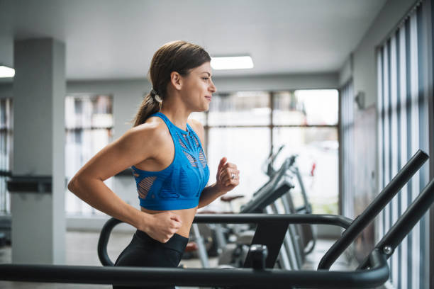istock Woman running on treadmill in gym. 1288921177