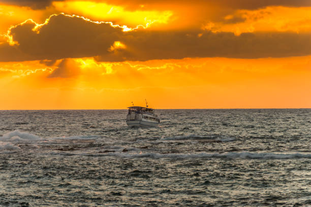 beautiful sunset and golden twilight, and clouds and a longly cruise ship sailing on the mediterranean sea in tel aviv, israel - sailboat sunset tel aviv sea imagens e fotografias de stock