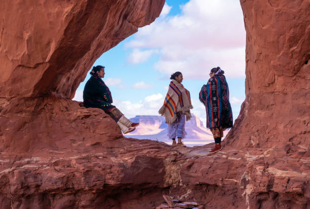 ein gespräch zwischen navajo-schwestern am tear drop arch im monument valley - arizona - navajo national monument stock-fotos und bilder