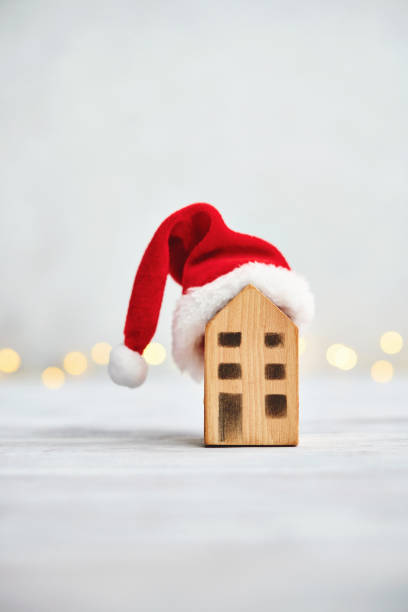 istock Christmas background with small house wearing Santa hat 1288936620