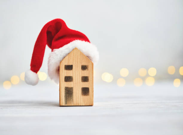 istock Christmas background with small house wearing Santa hat 1288936623