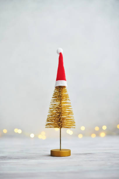 istock Gold Christmas Tree with Santa Hat Holiday Background 1288943075