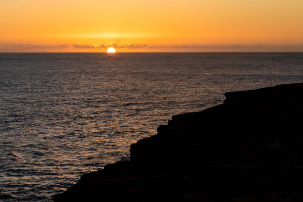 istock Sunset over the ocean with cliffs in hawaii 1288945982