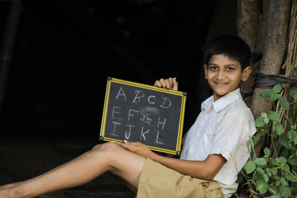 indian child writing a b c d alphabet on chalkboard - blackboard teaching preschool alphabet imagens e fotografias de stock