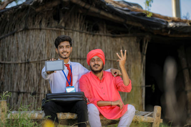 istock Young Indian bank officer showing mobile screen with farmer 1288947459