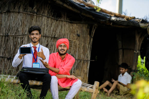 istock Young Indian bank officer showing mobile screen with farmer 1288948584