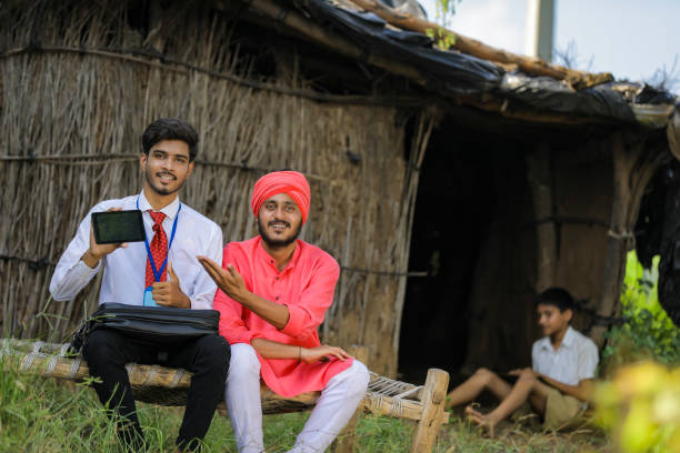 istock Young Indian bank officer showing mobile screen with farmer 1288948592