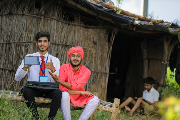 istock Young Indian bank officer showing mobile screen with farmer 1288948601