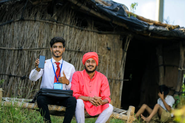 istock Young Indian bank officer showing mobile screen with farmer 1288948610