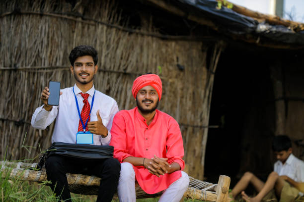 istock Young Indian bank officer showing mobile screen with farmer 1288949176