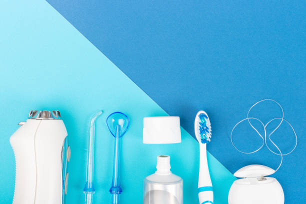 istock Toothpaste, toothbrush and dental irrigator on blue background, copy space. 1288949241