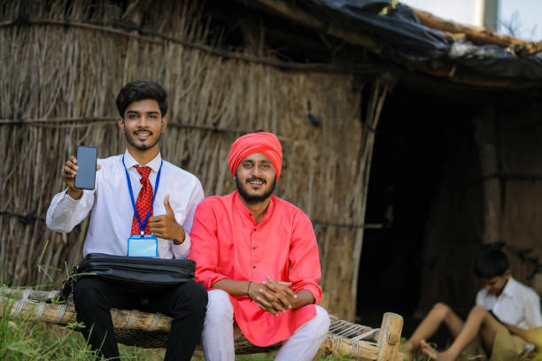 istock Young Indian bank officer showing mobile screen with farmer 1288949251