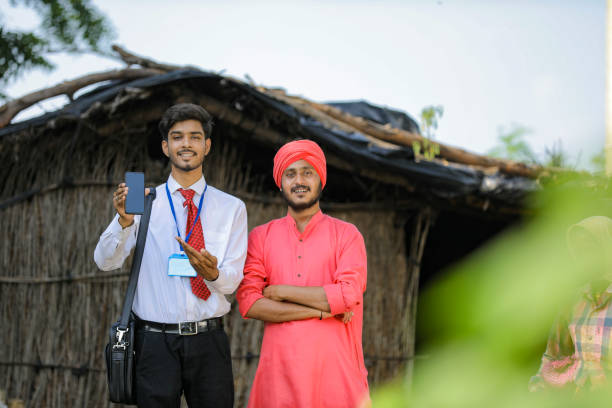 istock Young Indian bank officer showing mobile screen with farmer 1288950141
