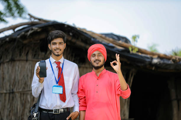 istock Young Indian bank officer showing mobile screen with farmer 1288950311