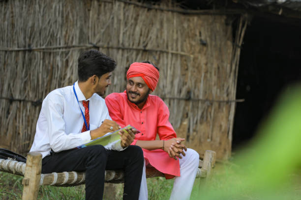 istock Young Indian banker discuss with farmer at home 1288954776
