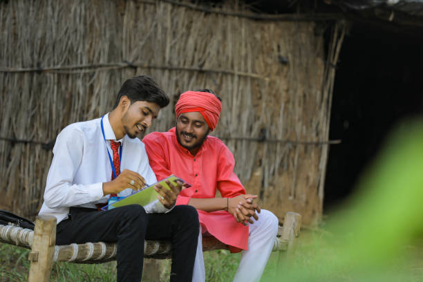 istock Young Indian banker discuss with farmer at home 1288954842