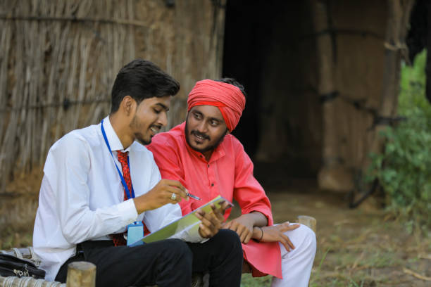 istock Young Indian banker discuss with farmer at home 1288954853