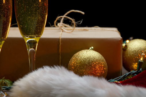 Christmas present on a table with champagne and a santa hat