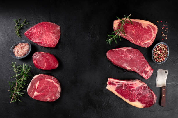 istock Meat, different cuts, shot from the top on a dark background with condiments 1288956859