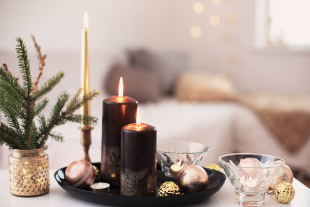 istock black burning candles with Christmas balls in white interior 1288957684