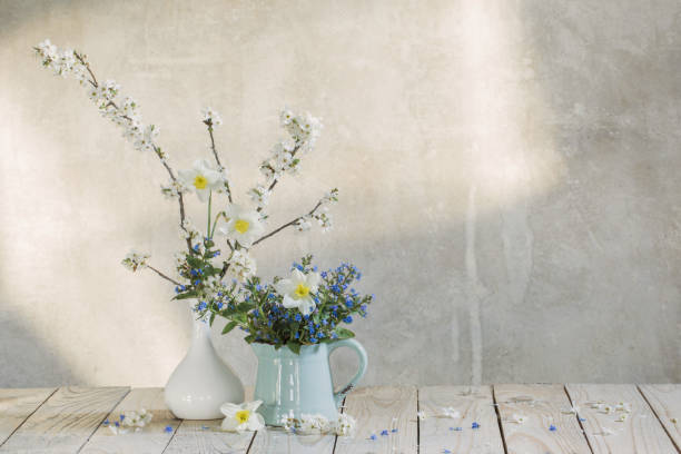 istock spring  flowers in  vases  on background old  wall 1288957705