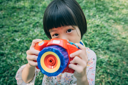 Asian little daughter playing with toys in the park