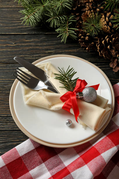 istock Concept of New year table setting with spruce branches on wooden background 1288959723