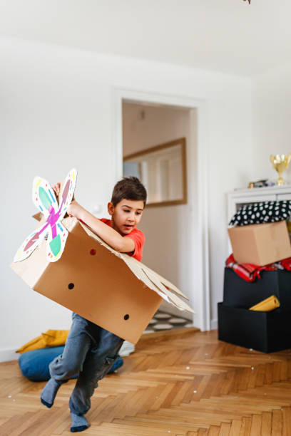 istock Boy pretending to fly a plane, wearing cardboard box with a propeller 1288960518