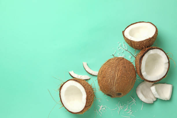 istock Fresh tasty coconut on mint background, top view 1288960522