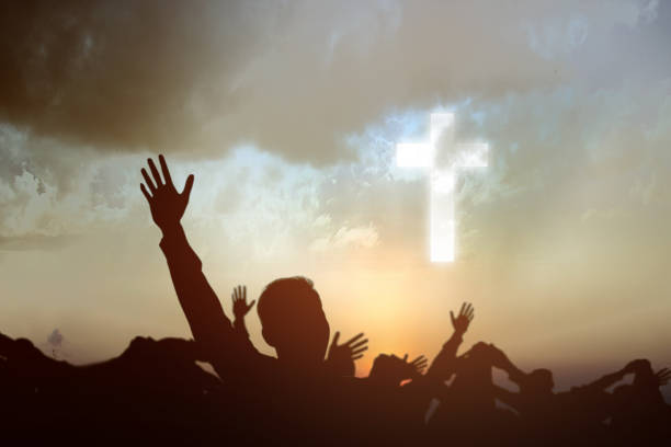 istock Silhouette of people looking at Christian cross 1288962139