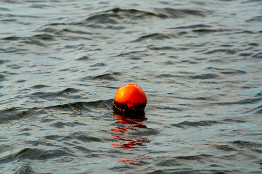 Orange buoy marker, marking the location of a crab pod left by a fisherman.