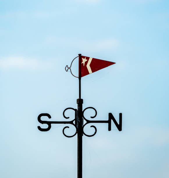 istock Wind vane with a small flag and north and south indicators. Made from cast iron painted black. 1288963531