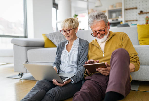 istock Cheerful senior couple using technology devices and having fun at home 1288965916