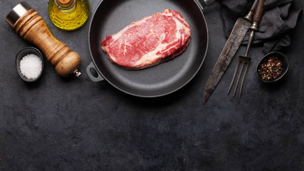 istock Raw beef ribeye steak on frying pan 1288968491
