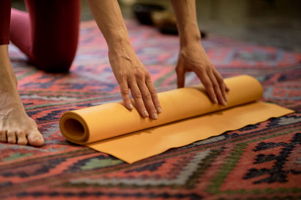 istock Woman rolling her mat after a yoga class 1288968507