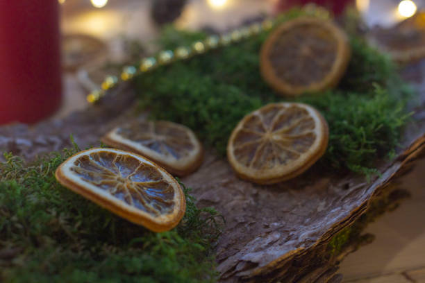 istock Christmas candles, lights, oranges, moss, bark, laying on table for decorating 1288971943
